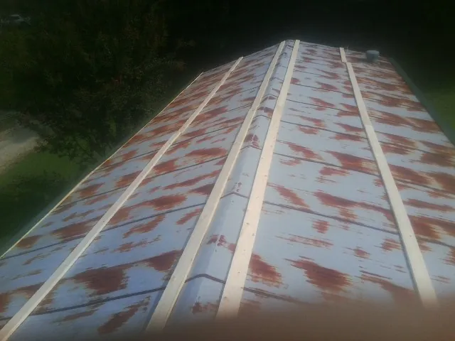 Rusted metal roof panels with new wood purlins before replacement — Storm Damage Roof Repair in Florence by Roofing Brothers